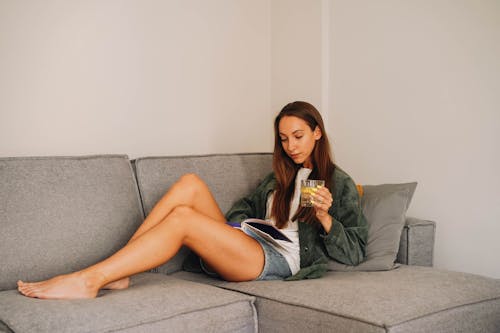 A Woman Reading a Book on the Sofa 