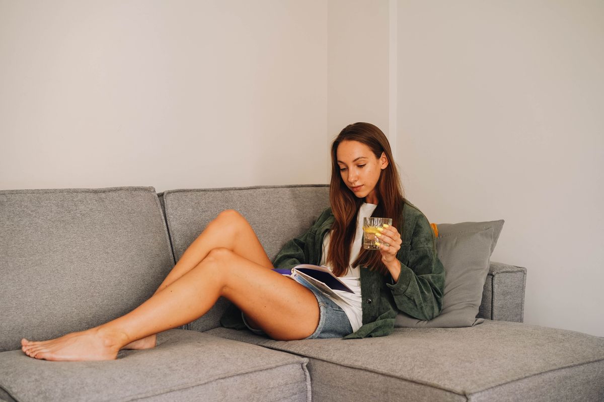 Woman reading on a sofa at home