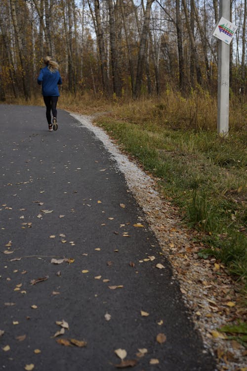 A Woman Jogging on a Road 