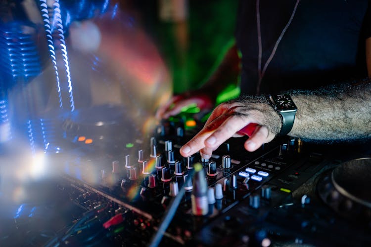 A Person Turning The Knob On A Control Panel