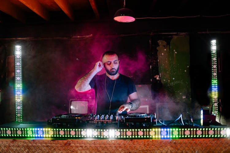 A Disc Jockey Playing Music On His Booth