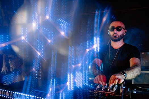 DJ performing at a nightclub with vibrant blue light effects, creating an energetic party atmosphere.