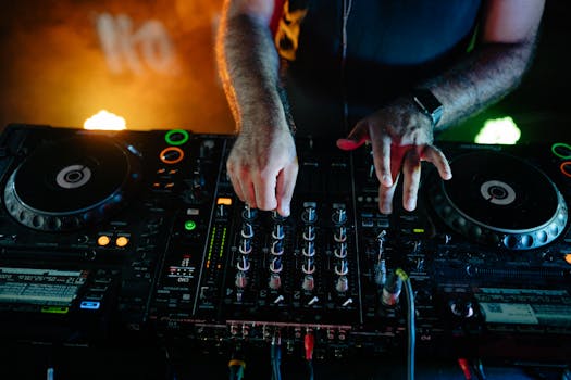 DJ performing vibrant set in a nightclub with advanced audio equipment under colorful lights.