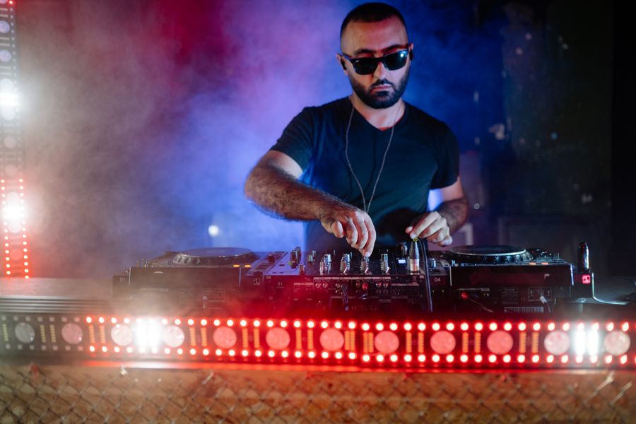 DJ aux platines sous des lumières rouges