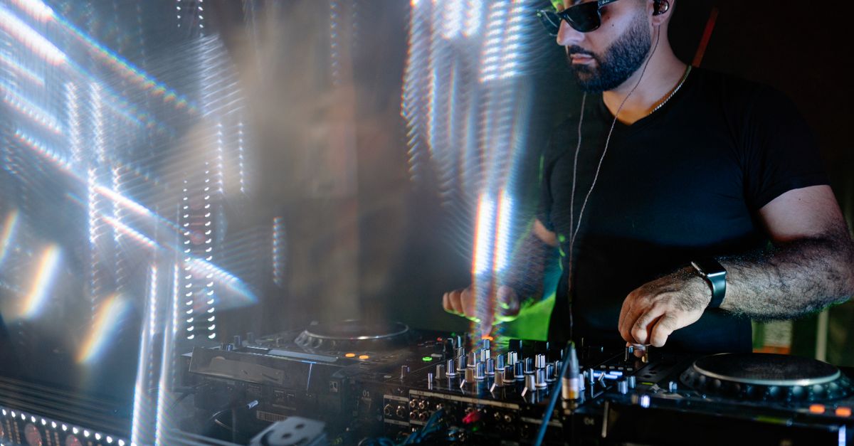 A Disc Jockey Wearing Black Shirt While Performing On A Nightclub A Disc Jockey Wearing Black Shirt While Performing On A Nightclub