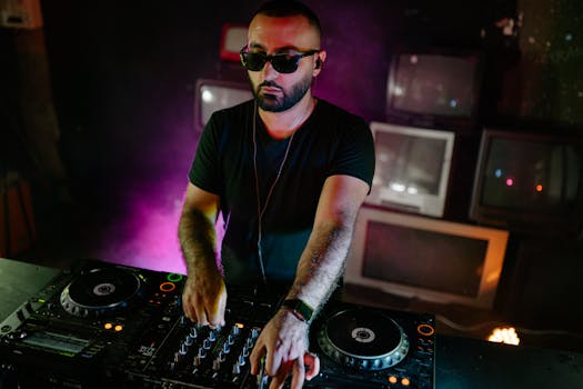 DJ performing with a mixer at a nightclub with vintage TVs in the background.