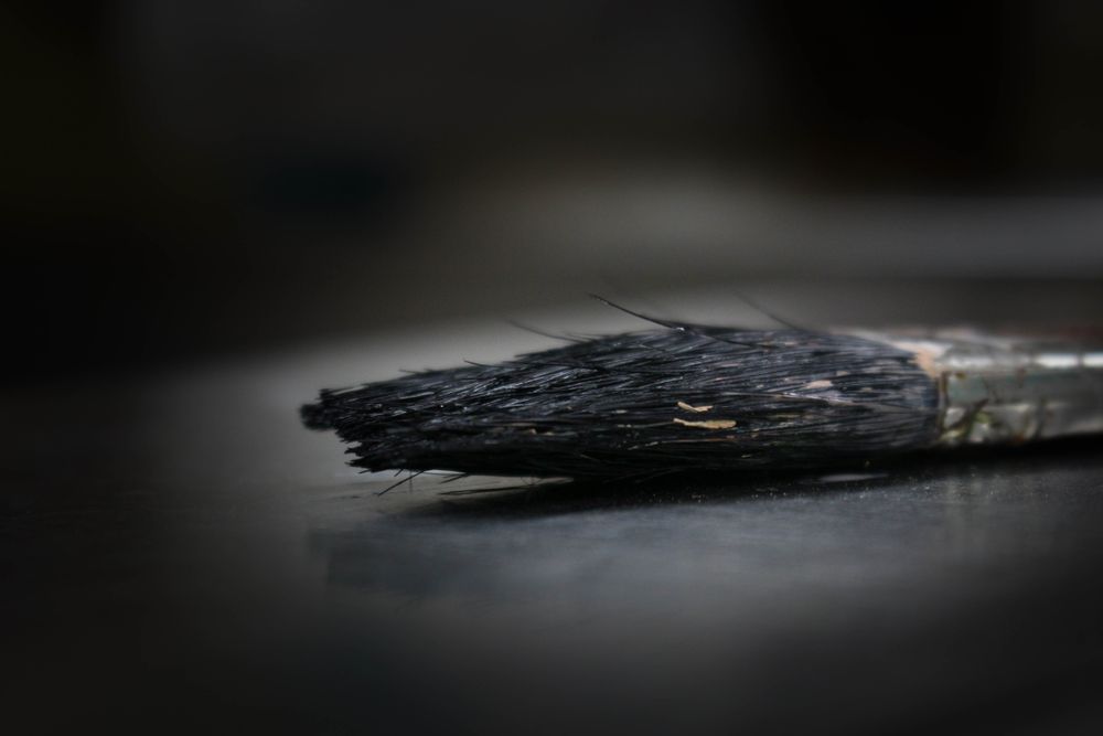 Close-up of a loaded paintbrush against fresh colour