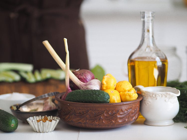 Assorted Kitchen Essentials In A Brown Bowl Beside A White Cup