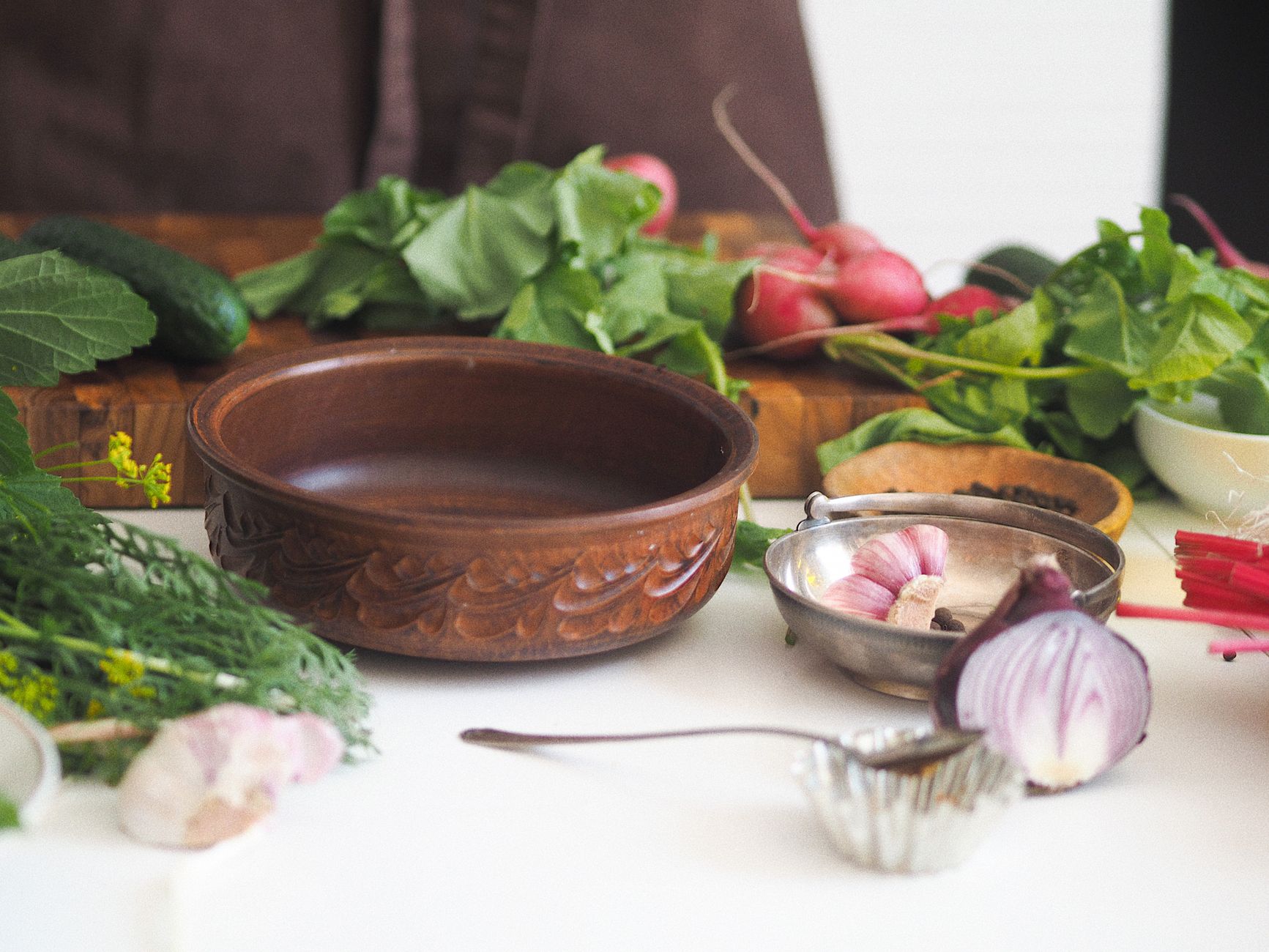 freshly pulled radishes with green tops on kitchen counter