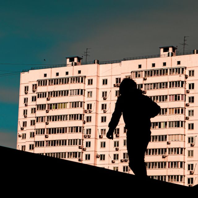Silhouetted figure on a rooftop against a high-rise at dusk, photo by Nikita Parev on Pexels