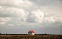 White and Red House on Brown Field Under Gray Sky