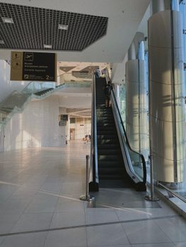 Spacious airport interior featuring escalator and modern design elements, perfect for travel themes.