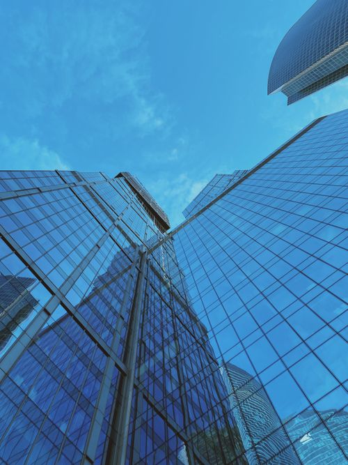 Free Stunning architectural low angle view of modern skyscrapers with reflective glass windows against a clear blue sky. Stock Photo