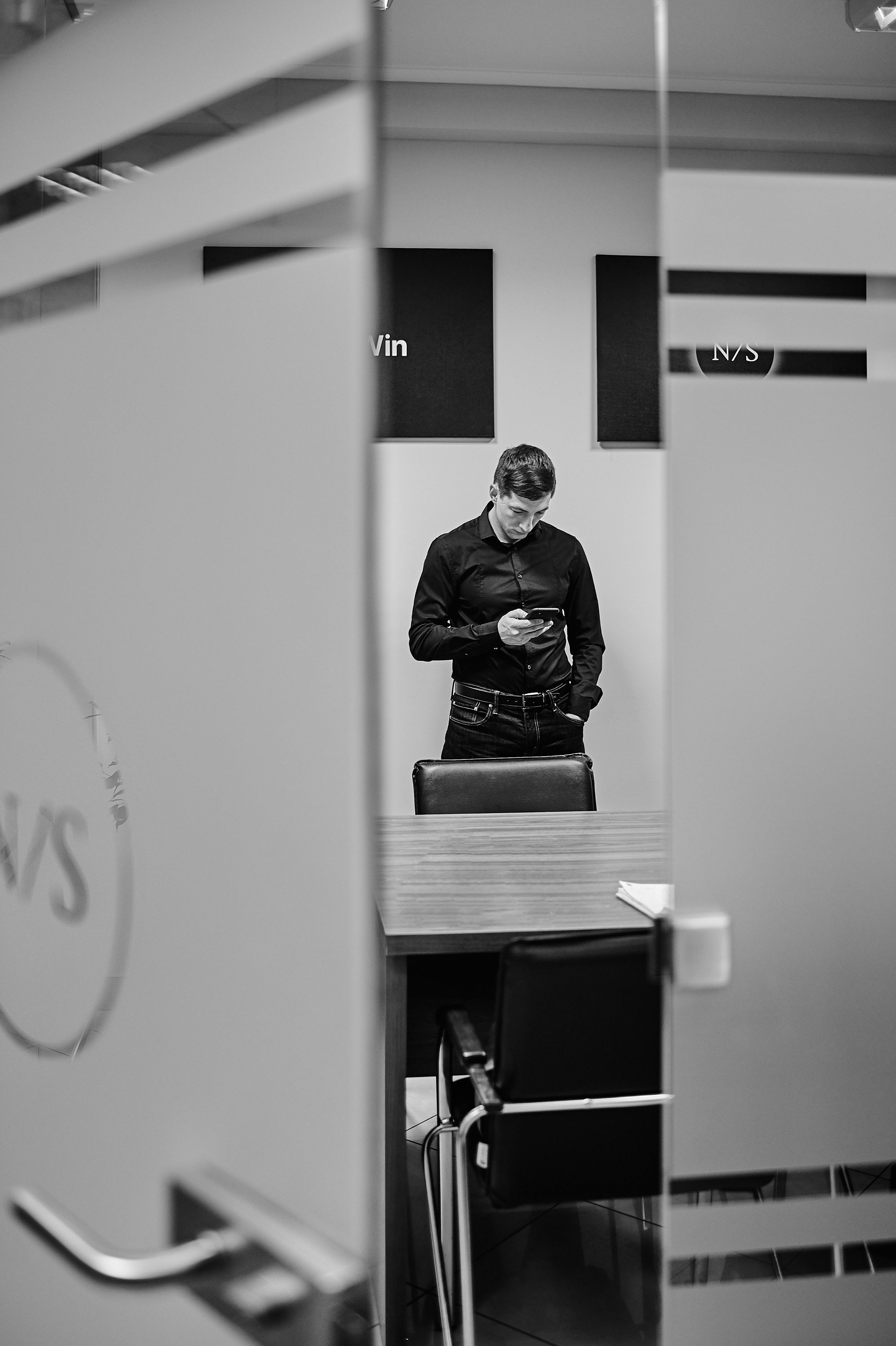 a man reflecting in a mirror while using smartphone