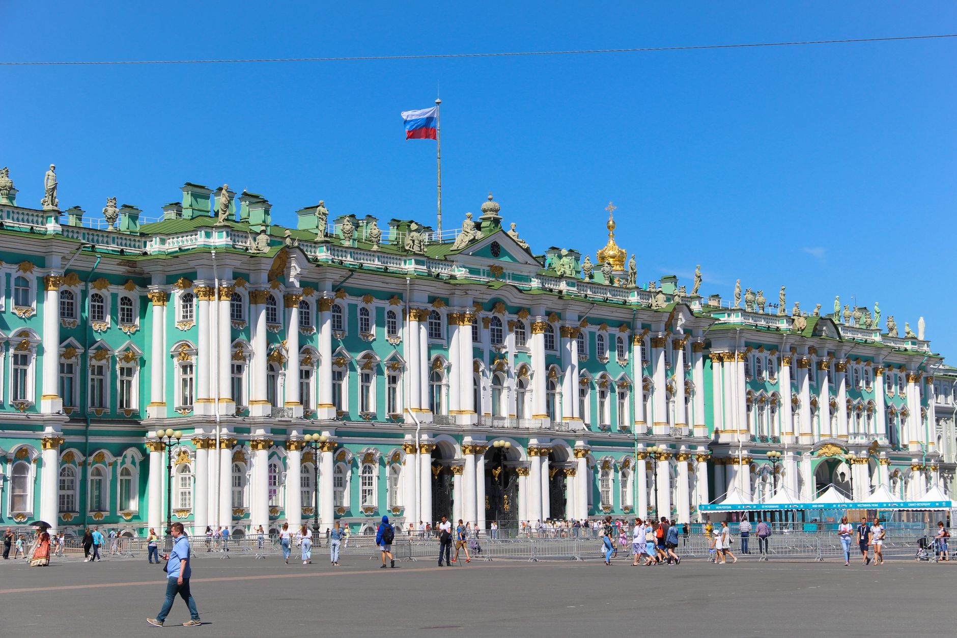 The majestic State Hermitage Museum facade in St. Petersburg, Russia, under a clear blue sky.