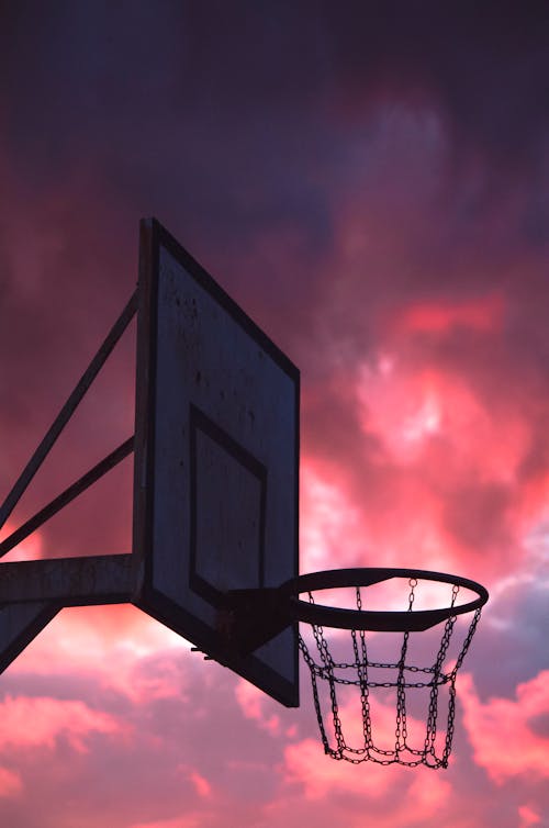Photo of a Basketball Hoop During Sunset
