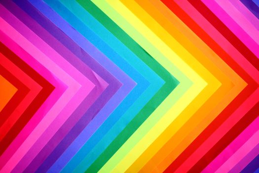 Colorful V-shaped paper pattern with vibrant rainbow hues and geometric design.