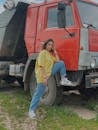 Woman in Yellow Oversize T-Shirt Standing Beside Red Truck