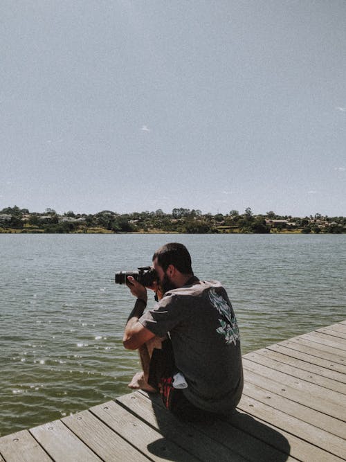 Photograph of a Man Taking a Photo on the Dock