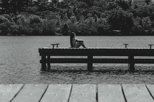 Free A Woman Sitting on the Lake wooden Dock Stock Photo