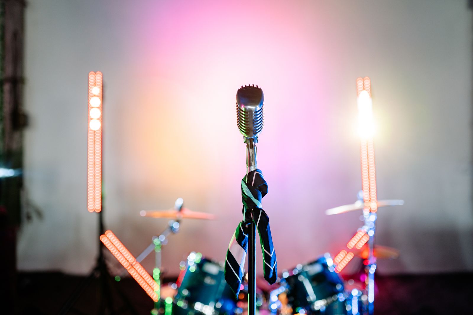 Vintage microphone and drum kit under stage lights