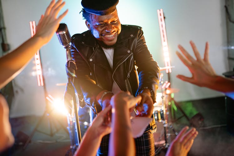 A Man In Black Leather Jacket Reaching For A Paper