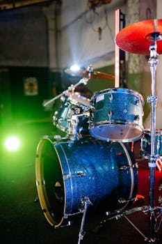 Close-up of a blue drum set under vibrant stage lights, ready for a live concert.