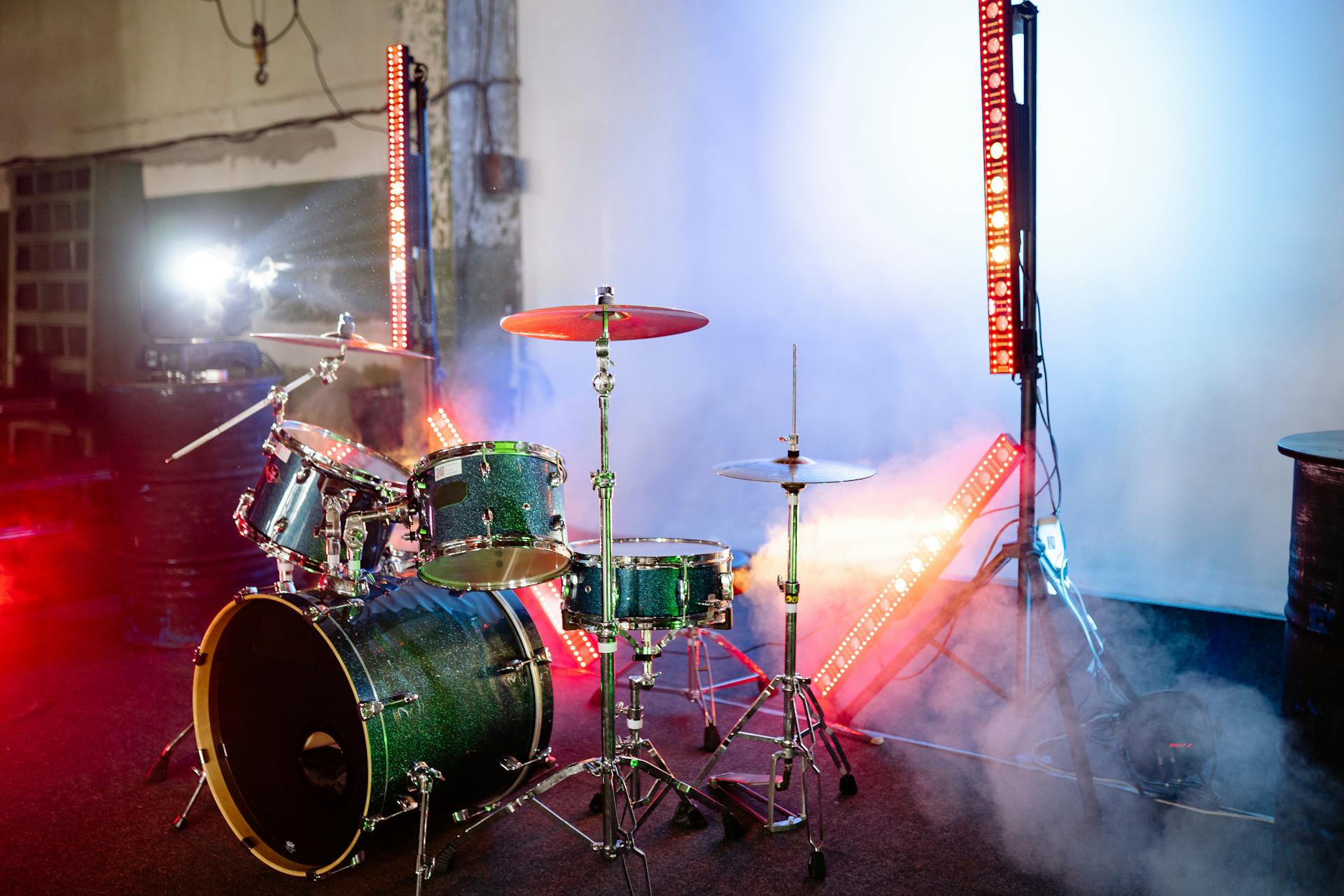 A Green Drum Set on a Stage with Smoke and Lights