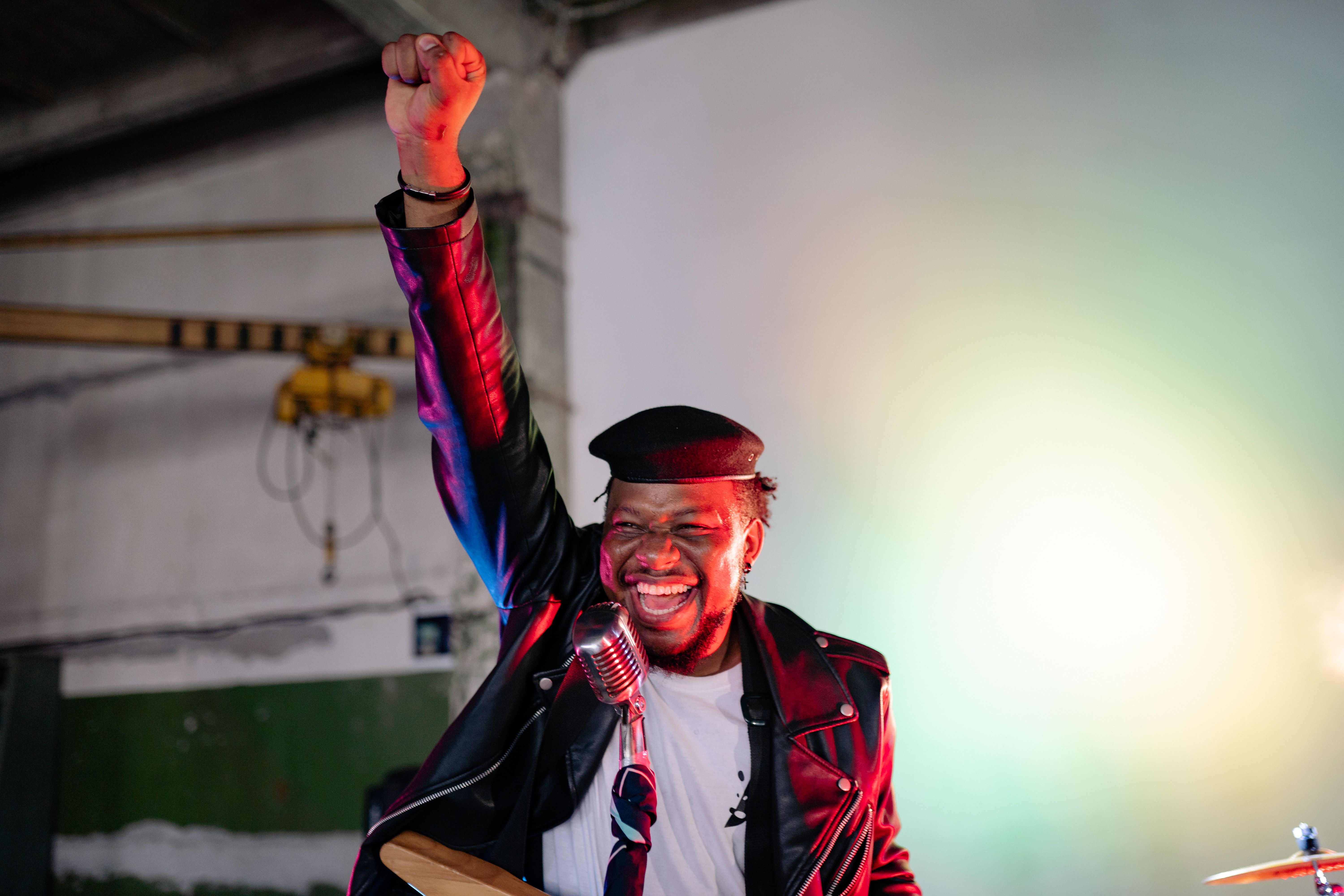 Singer Wearing Leather Jacket Performing on Stage · Free Stock Photo