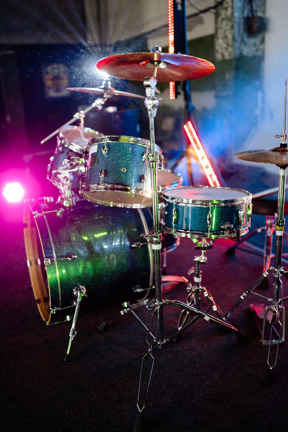 Drum kit lit by pink and blue stage lights