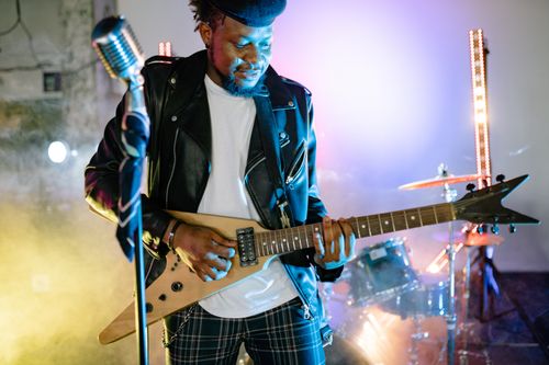 Free A musician passionately playing electric guitar at a vibrant concert with colorful stage lights. Stock Photo