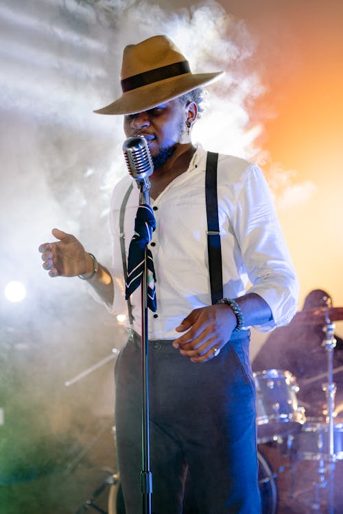 A Man Wearing a Hat While Singing 