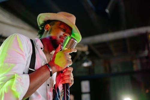 A Man Holding a Microphone While Singing 
