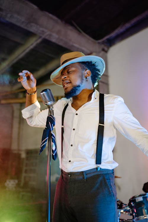 Free A Man Wearing a Long Sleeve Shirt and a Hat Singing  Stock Photo