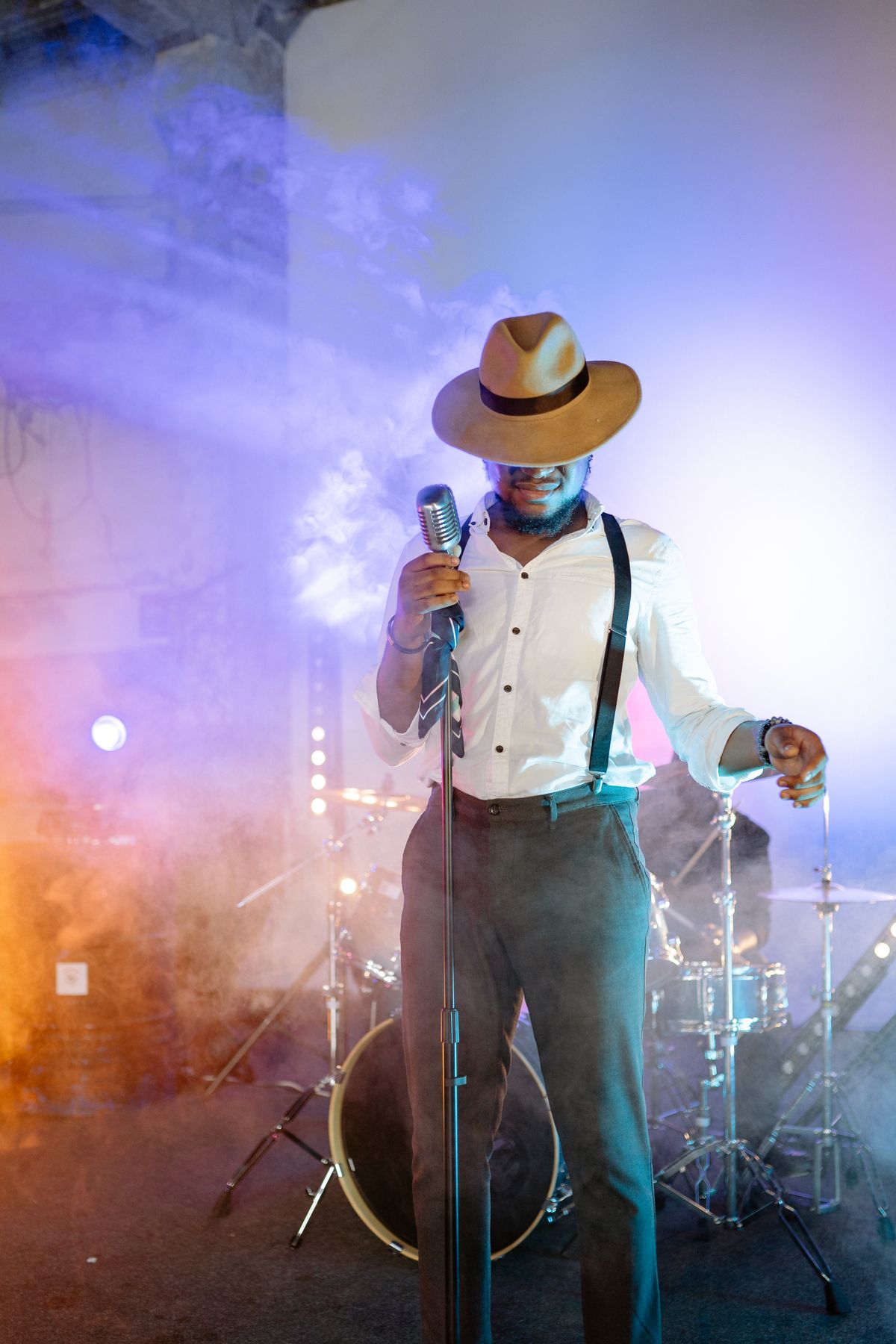 Vocalist on stage holding a vintage microphone under dramatic lighting