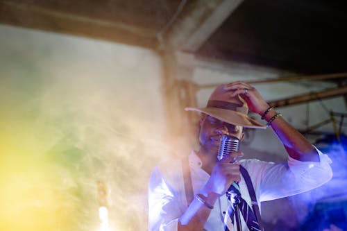 Free Photograph of a Man with a Brown Hat Holding a Microphone Stock Photo