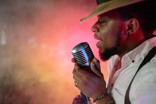 Free Captivating image of a man singing passionately into a retro microphone. Music vibes. Stock Photo