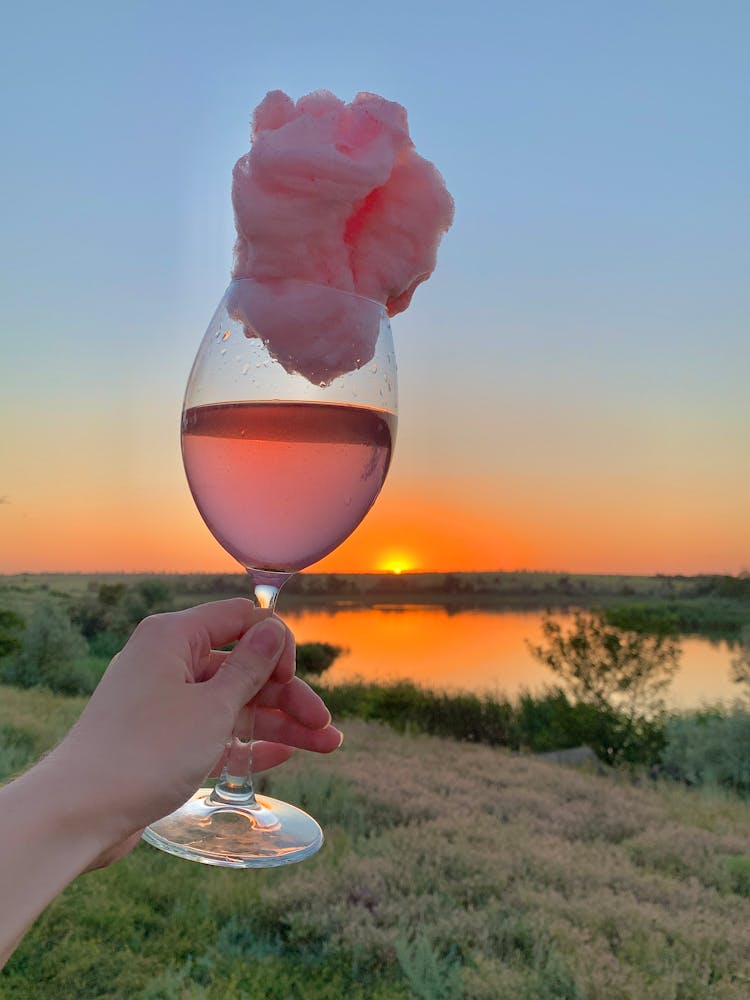 A Person Holding A Glass Of Drink With Cotton Candy