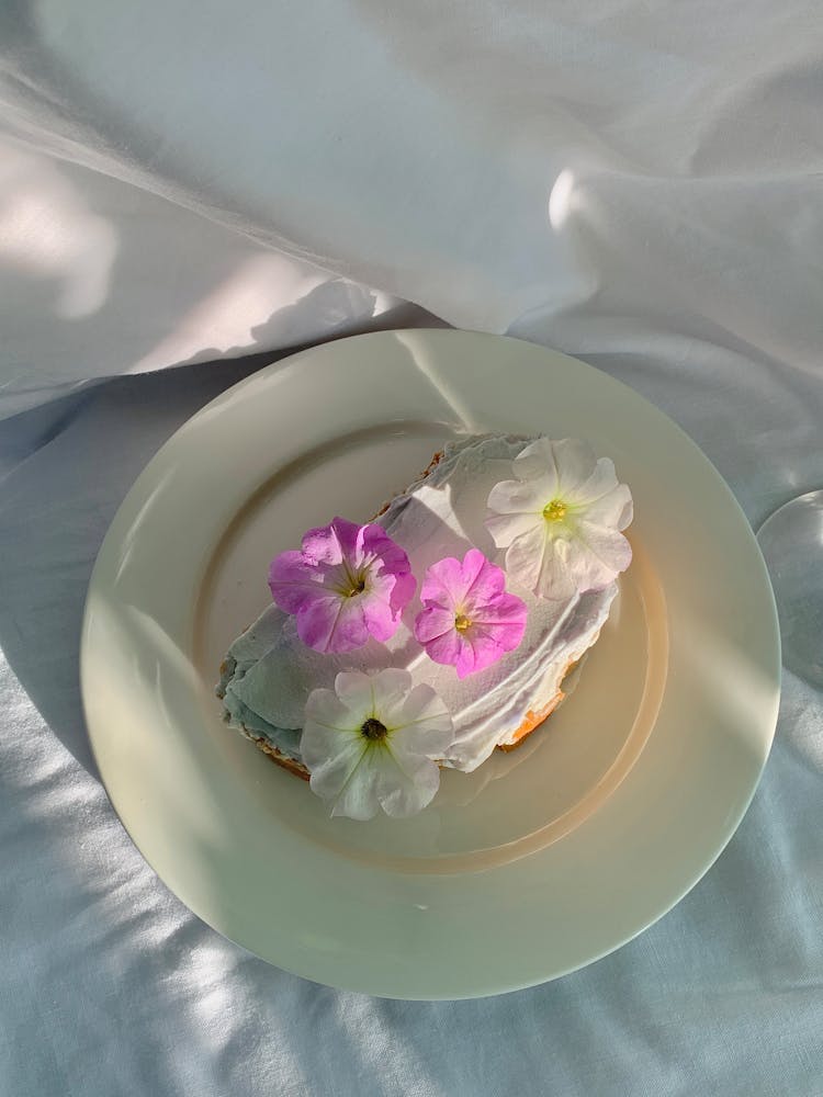 A Cake With Cream And Flowers On Top