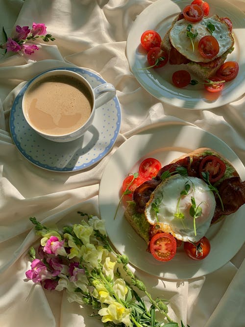 A Ceramic Plates with Foods Near the Saucer with Cup of Coffee