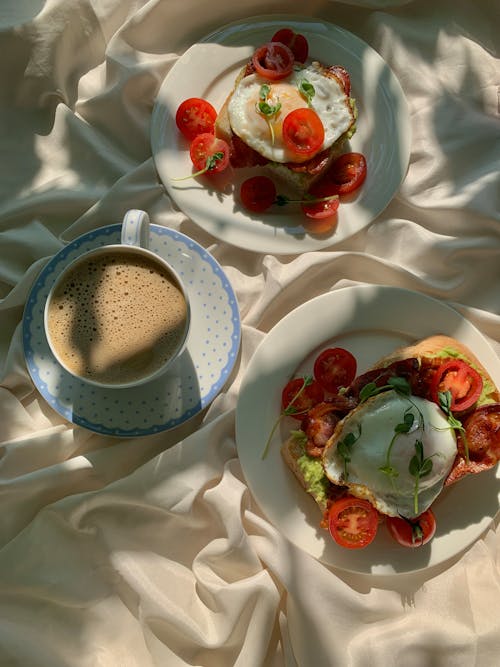 Free Bacon Egg Toasts and a Cup of Coffee on White textile Stock Photo