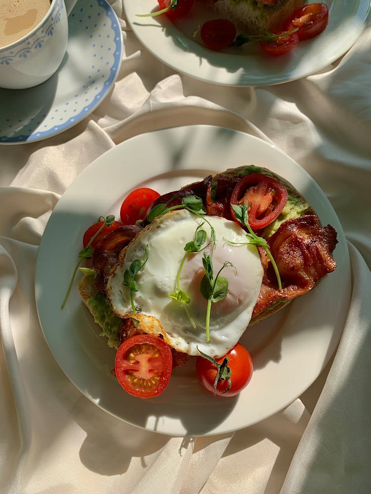 A Delicious Bacon And Egg Toast On A Plate Topped With Leaves