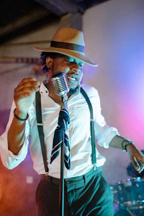 A Man in Brown Hat Singing and Dancing
