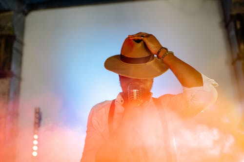 Free Singer Wearing Brown Hat Singing on Stage Stock Photo