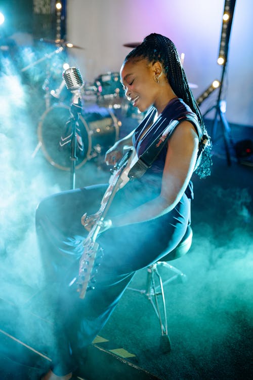A Woman Singing While Playing the Guitar 