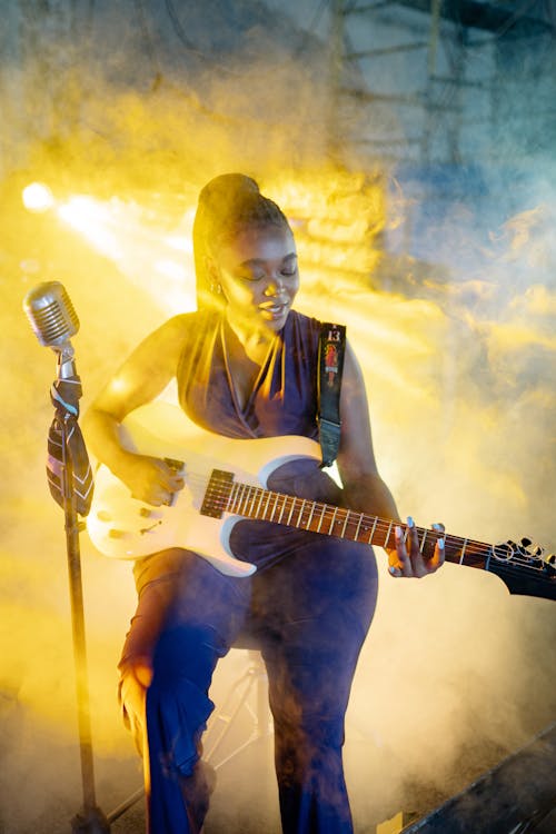 Woman Playing Electric Guitar on Stage