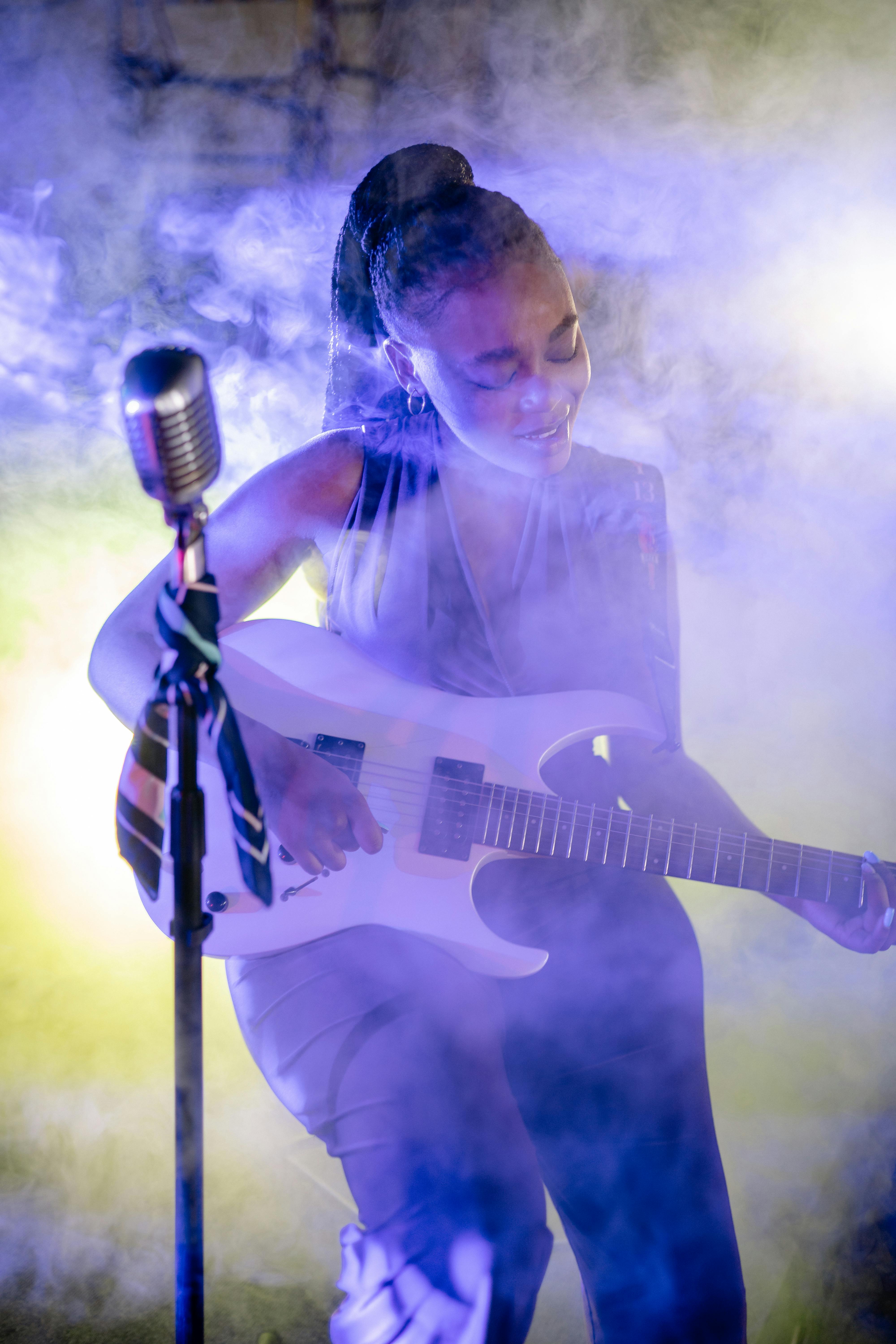 photograph of a woman playing the electric guitar