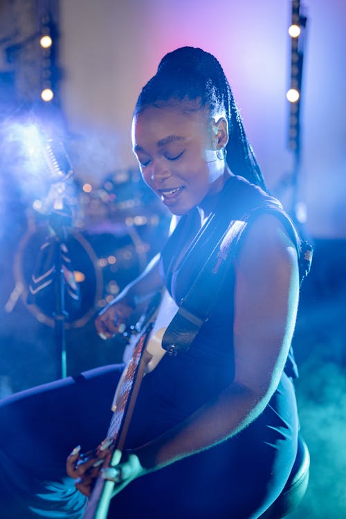 A Woman Singing and Playing the Guitar 