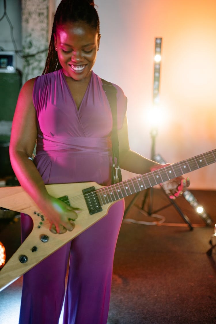 Woman In Purple Suit Playing Electric Guitar