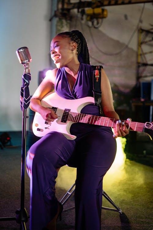 A Woman Singing and Playing the Electric Guitar